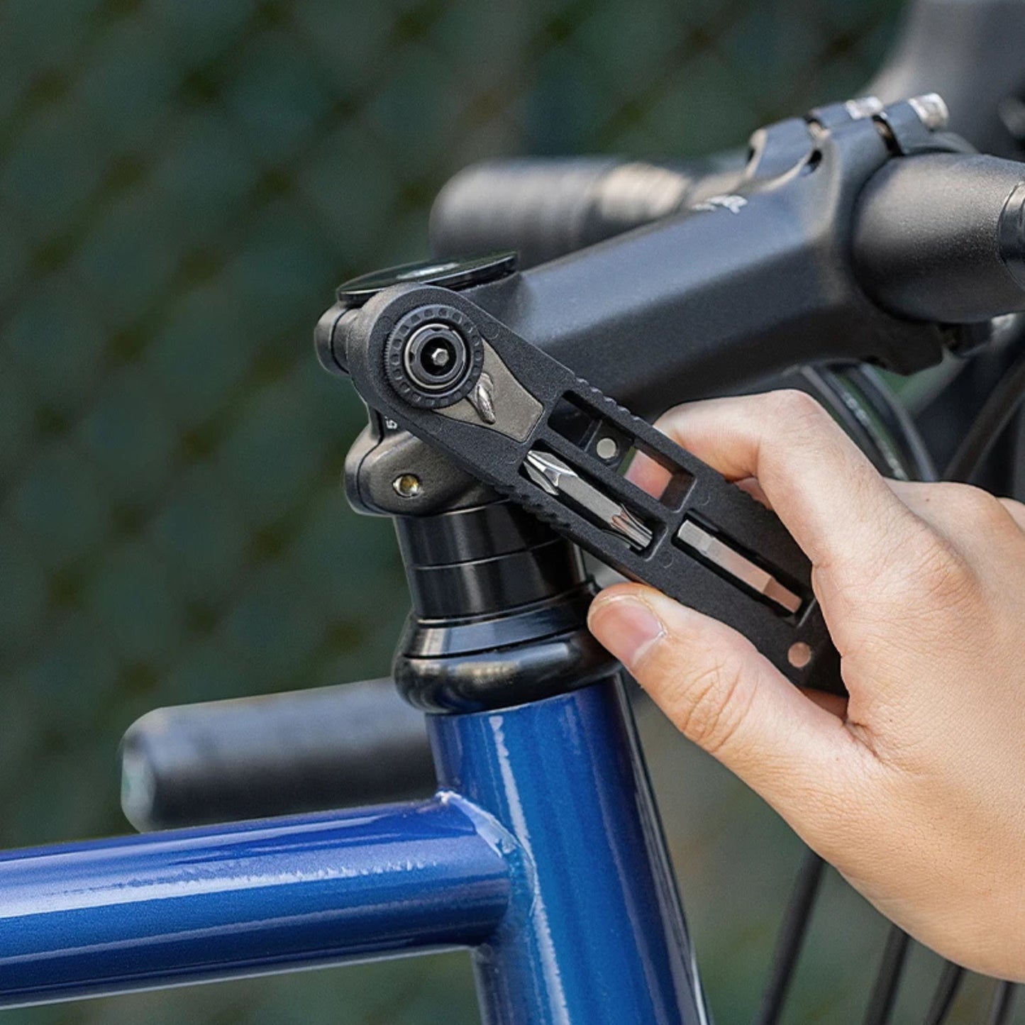 Hand verwendet die Ratsche des 16-in-1 Fahrrad Multitools am Fahrradlenker für effiziente Anpassungen
