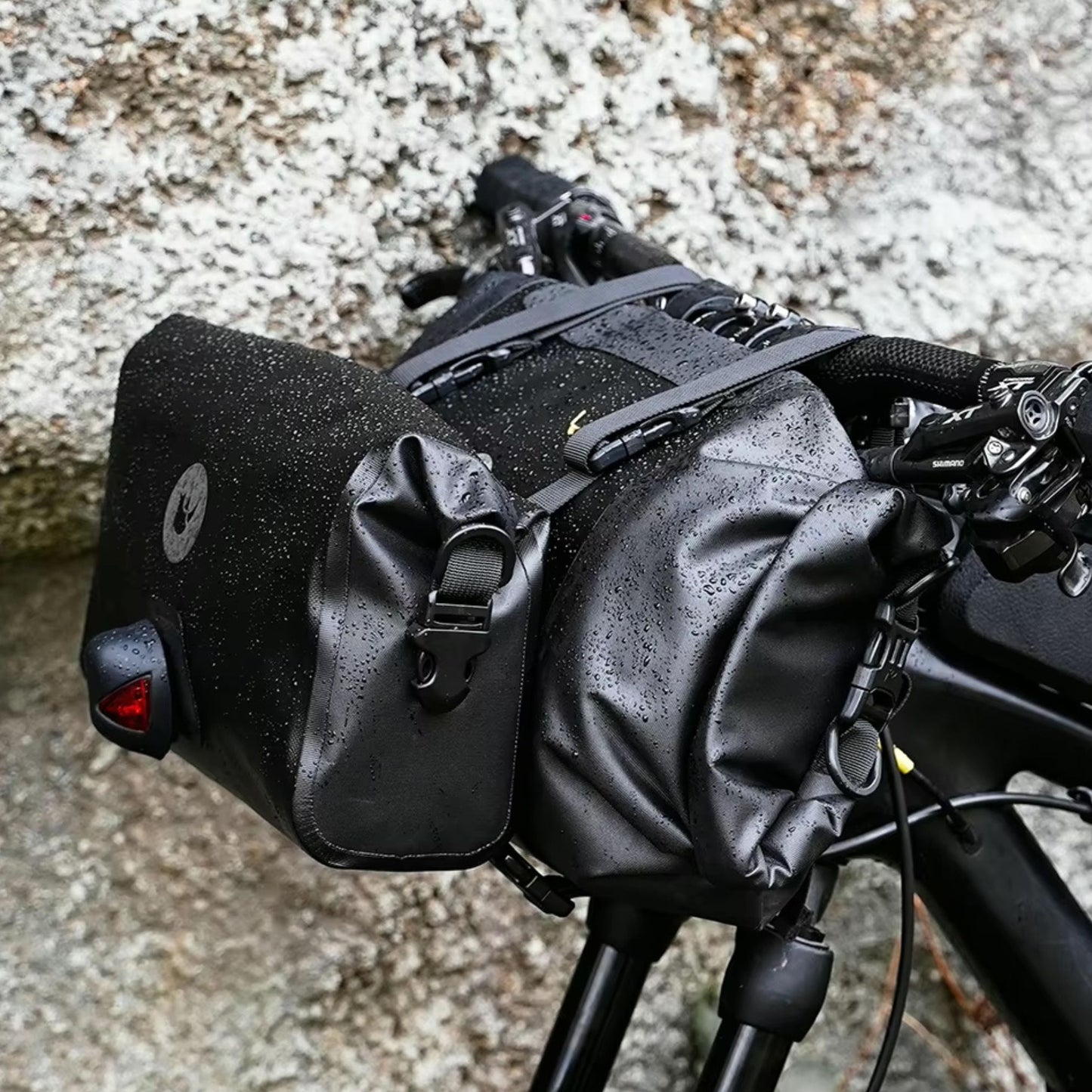 Rhinowalk Fahrrad-Lenkertaschen Set in schwarzer Ausführung, wasserdichtes Material, Nahaufnahme der nassen Taschen, Details zu Befestigungselementen und Markenlogo sichtbar.