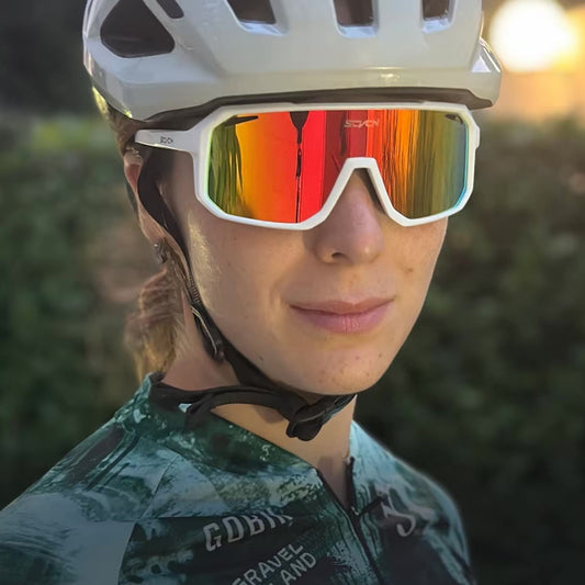 Fahrradfahrerin trägt Ultraleichte Fahrradbrille mit rotem Glas und weißem Rahmen – sportlich und modern