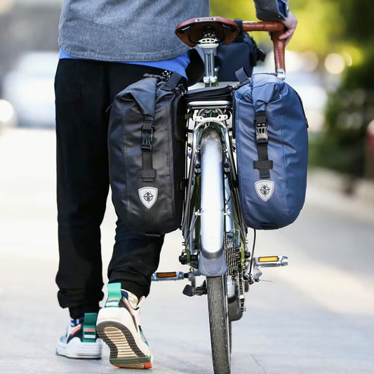 Rhinowalk Fahrradtaschen 20L im Einsatz: Schwarze und blaue Taschen sicher am Gepäckträger befestigt.
