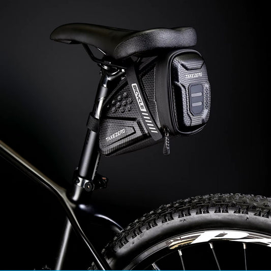 Die Takezero Satteltasche im Einsatz: Ein Mountainbiker fährt mit der Tasche auf einem Trail. Die Tasche sitzt fest am Sattel und stört nicht beim Fahren.