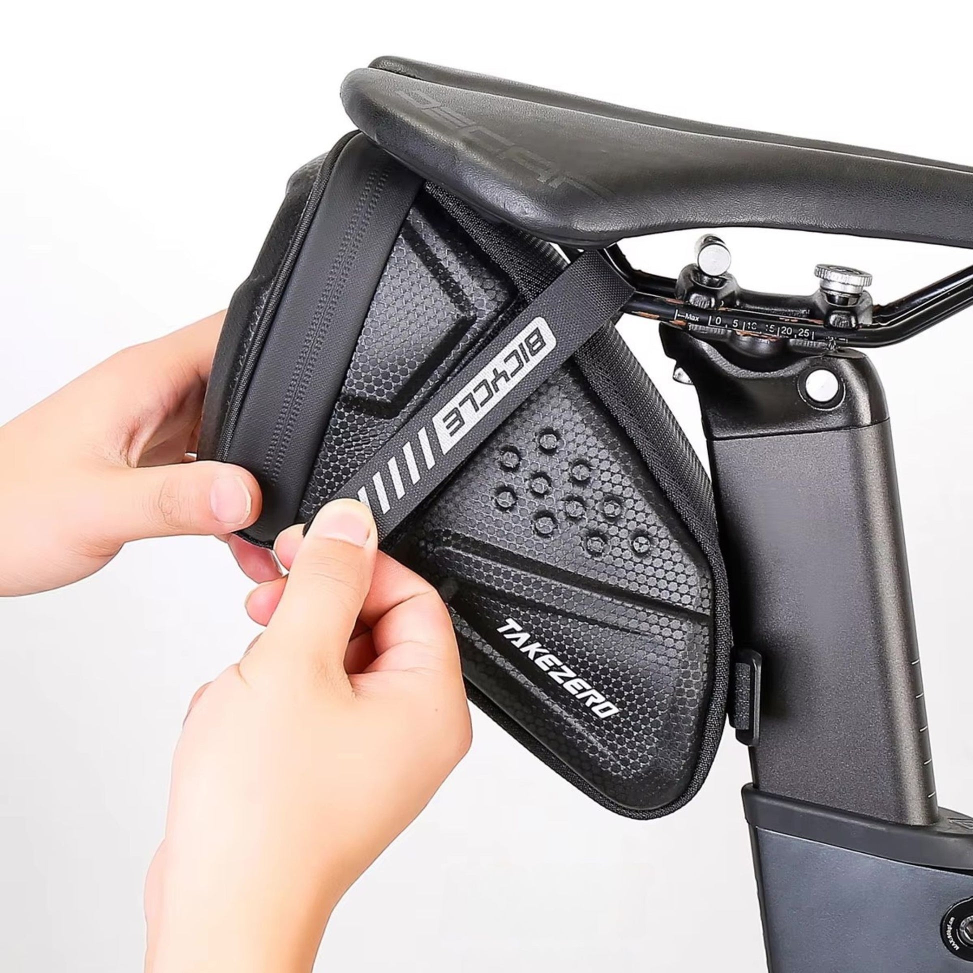Einfache Montage: Eine Hand befestigt die Takezero Satteltasche werkzeugfrei am Fahrradsattel. Schnell und unkompliziert.
