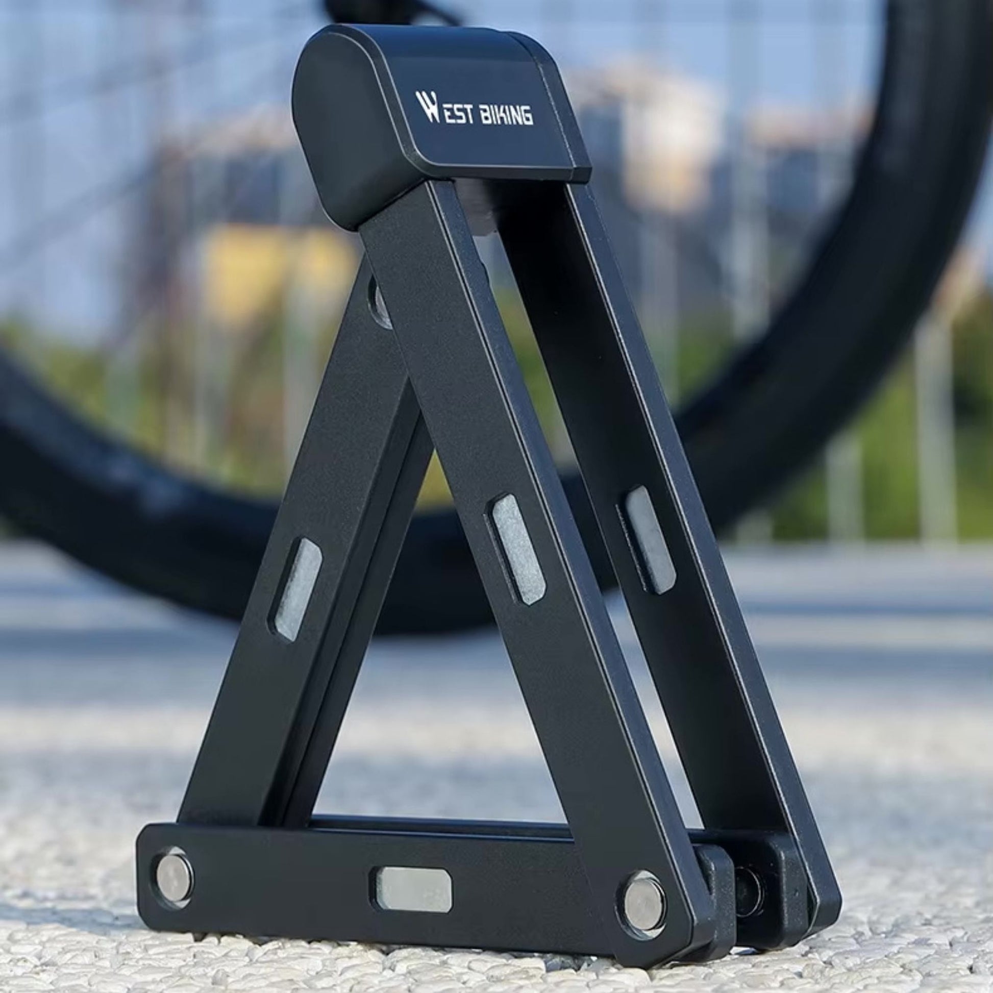 Hochsicherheits-Faltschloss im aufgeklappten Zustand vor einem Fahrrad. Bereit für den Einsatz.
