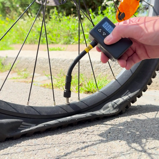 offtrails e-Pump, aufpumpen ohne Hände, Produktvideo Cover, Hand hält elektrische Fahrradpumpe ans Ventil